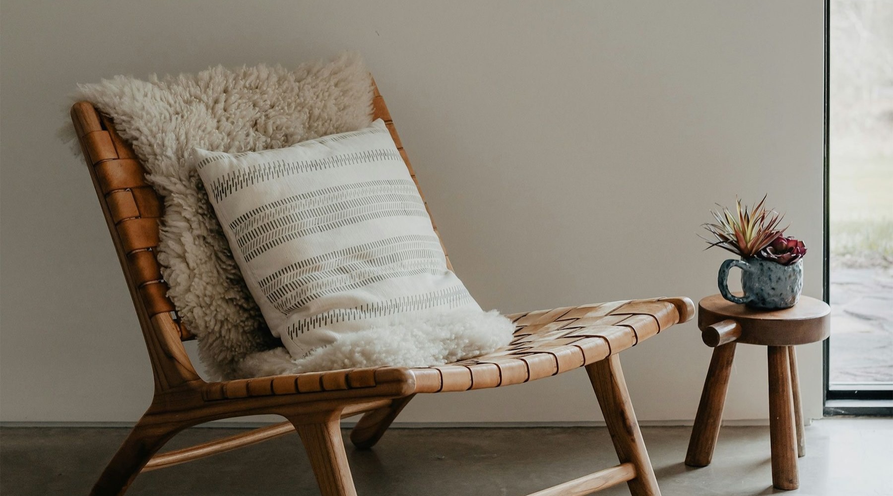 a chair in a room with a small cup on a small stool