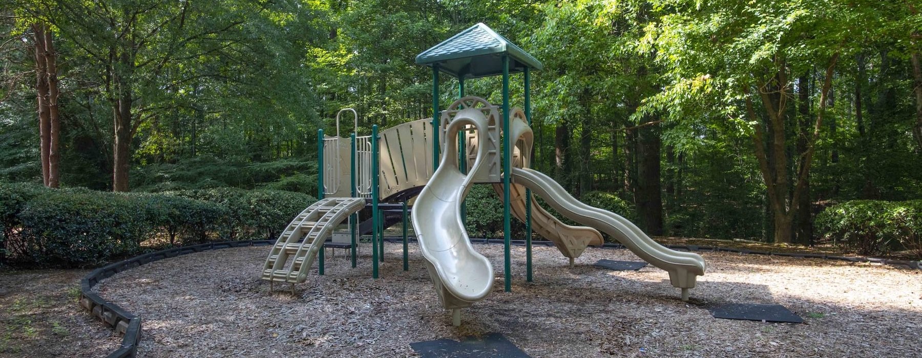 a playground with trees and bushes