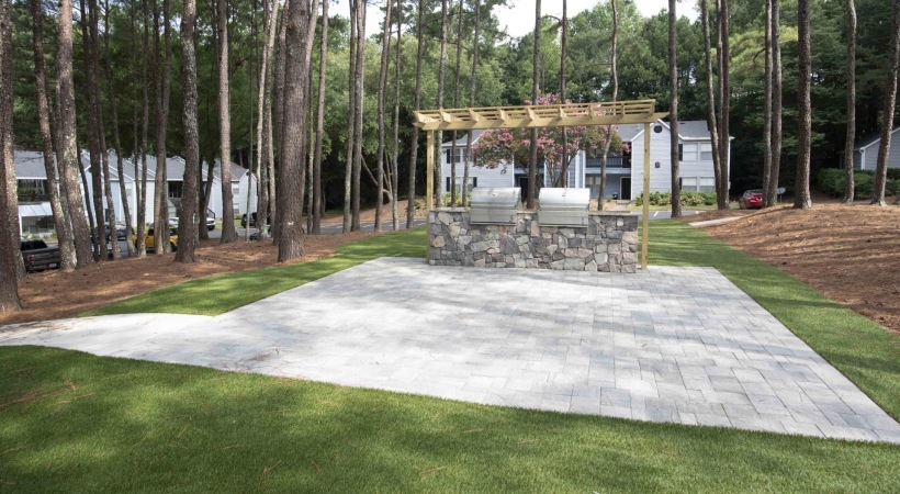 a stone patio with a grill area