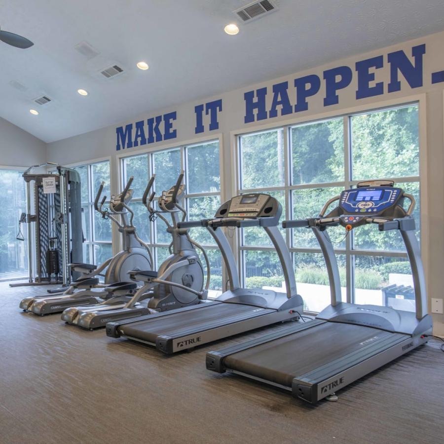 gym with treadmills lining the windows