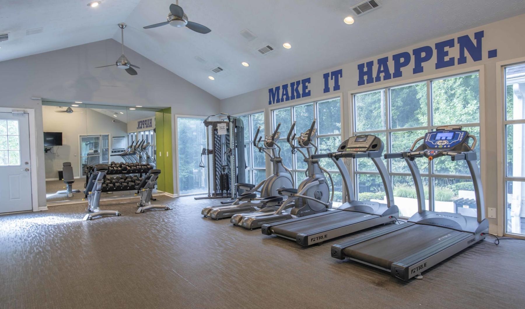 gym with treadmills lining the windows