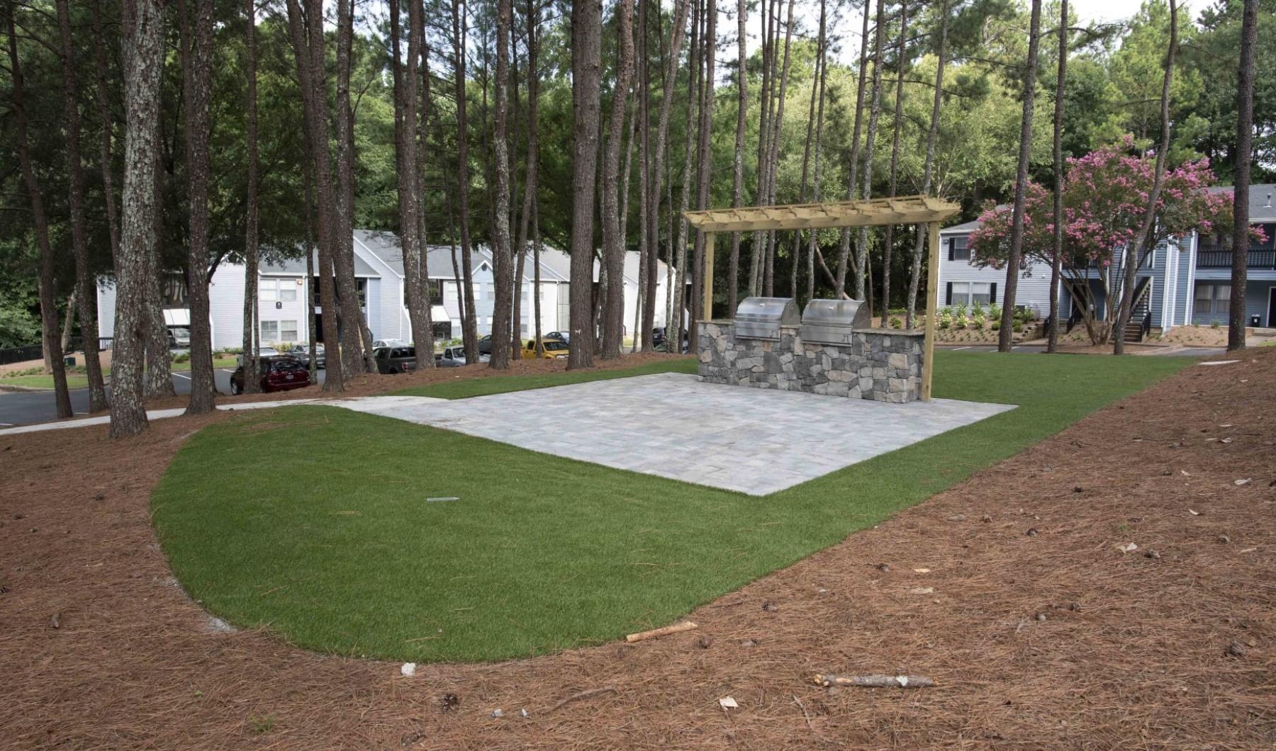 a large green lawn with a gazebo and trees
