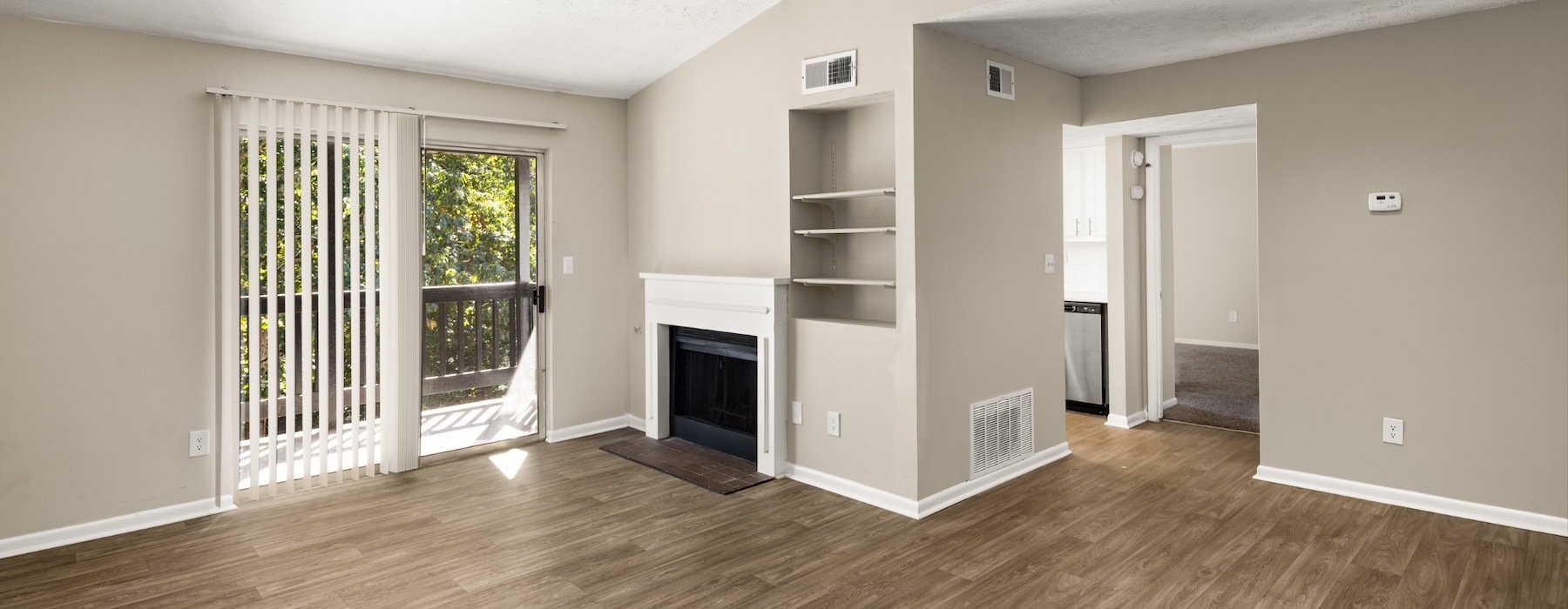 a living room with a fireplace and wood floors
