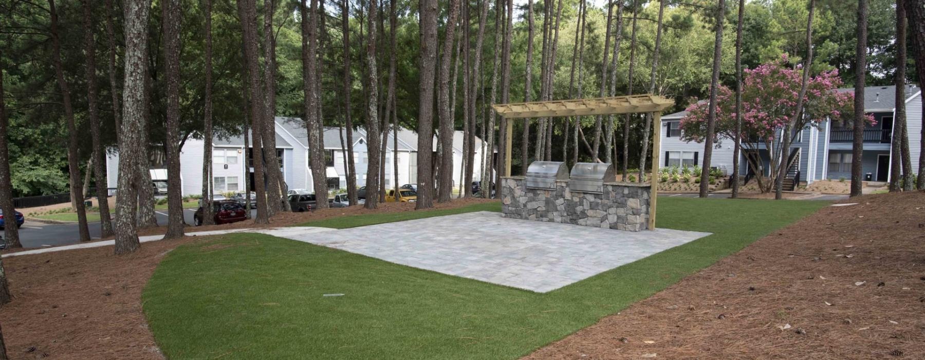 a large green lawn with a gazebo and trees